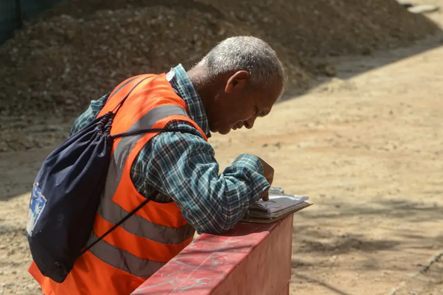 Worker in hi-vis filling in his hours